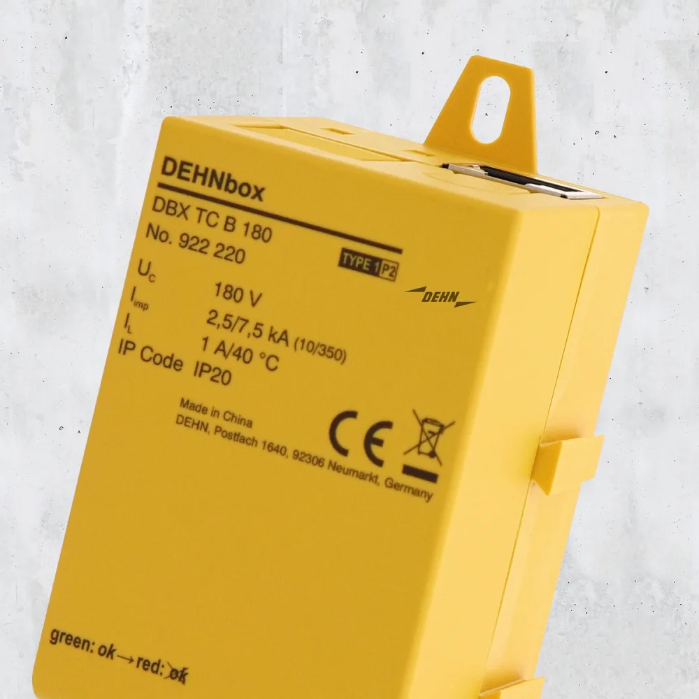 Close-up of a yellow DEHNbox surge protection device showing product label and mounting tab.