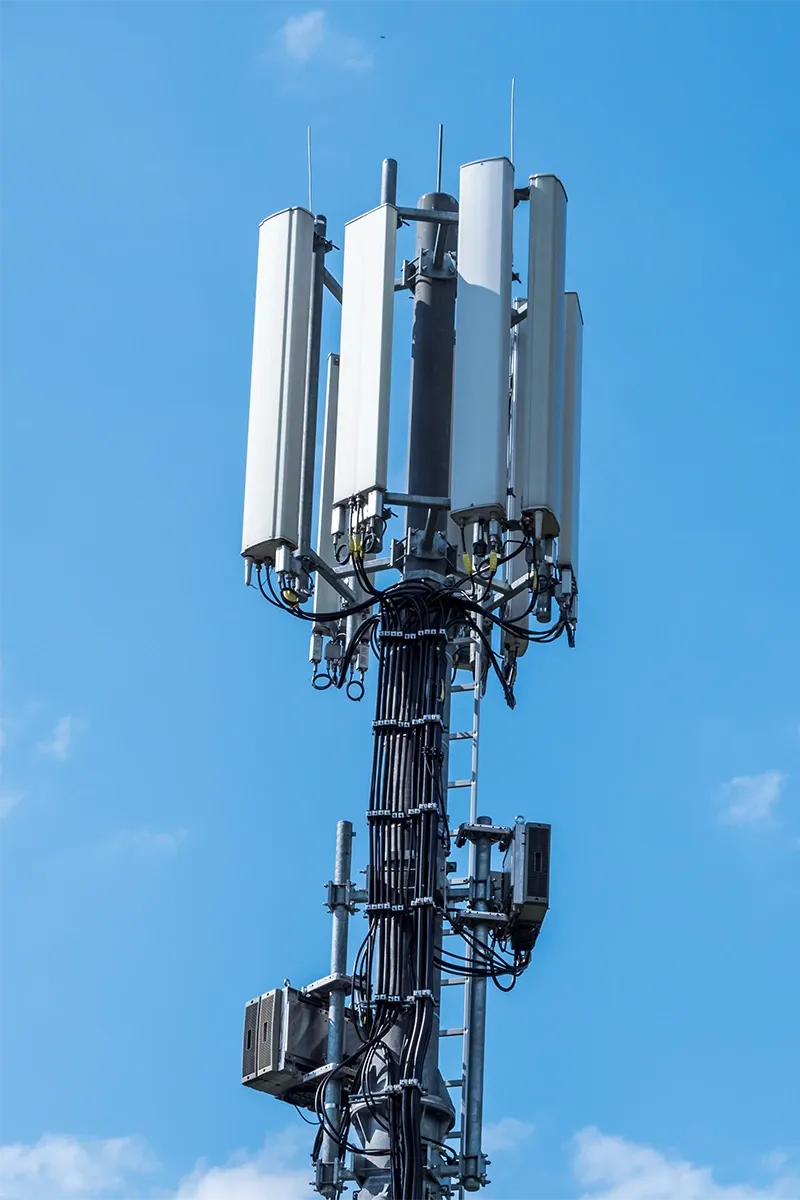 Mobilfunkmast mit Antennen vor blauem Himmel