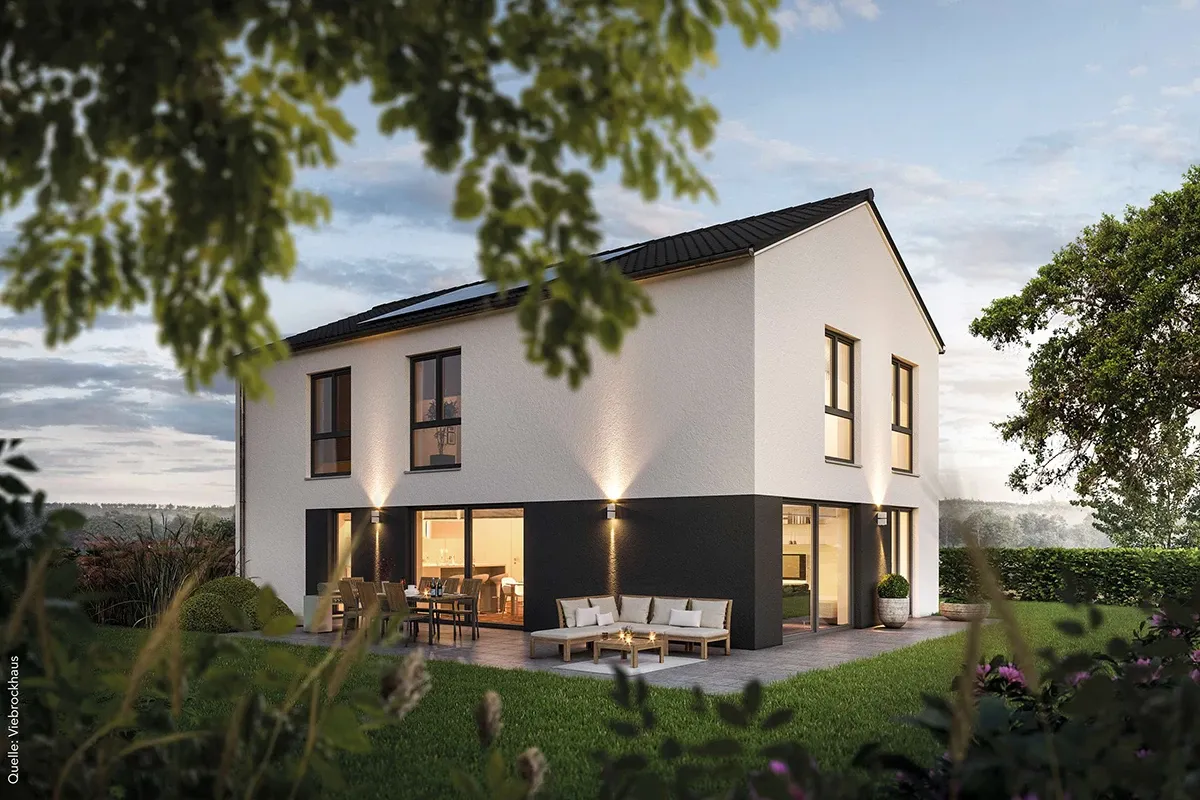 Single-family house with indirect lighting and a lot of plants in the garden at dusk